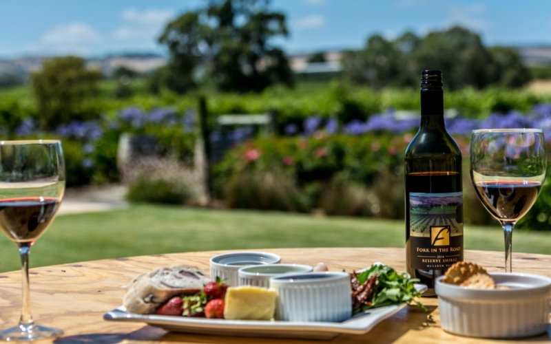 A bottle of our wine, with two glasses poured and one of our regional platters on offer.