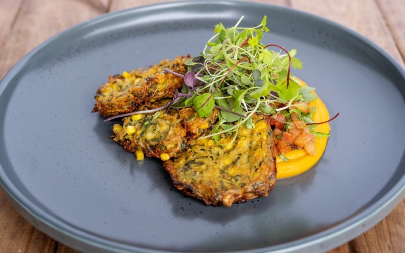 Corn and Pea Fritters served with Spiced Pumpkin Puree, fresh salsa and red vein sorrel salad