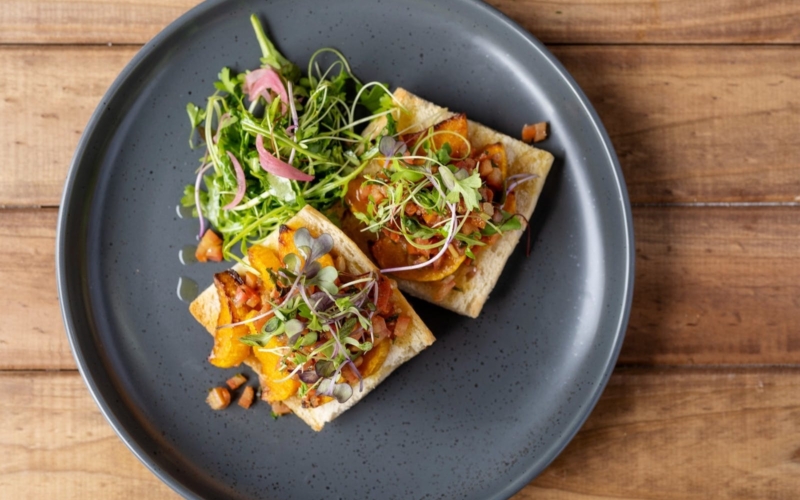 Honey Miso Pumpkin toast with fresh tomato salsa, toasted pine nuts, finished with petite herbs