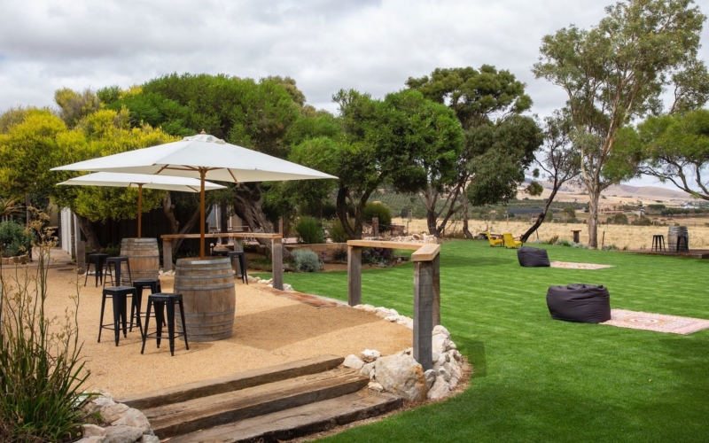 Outdoor area, including wine barrels, umbrellas, stools, rugs and beanbags